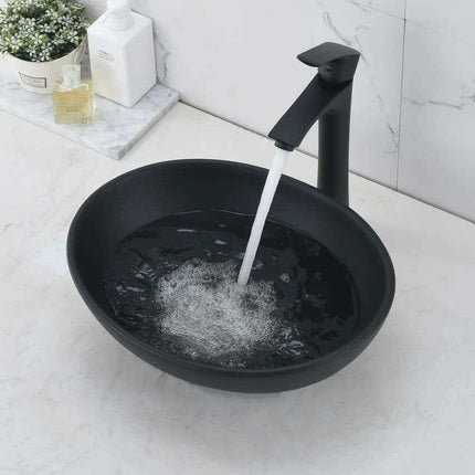 Elegant Oval Ceramic Sink Ensemble with Black Faucet and Stainless Steel Drain..