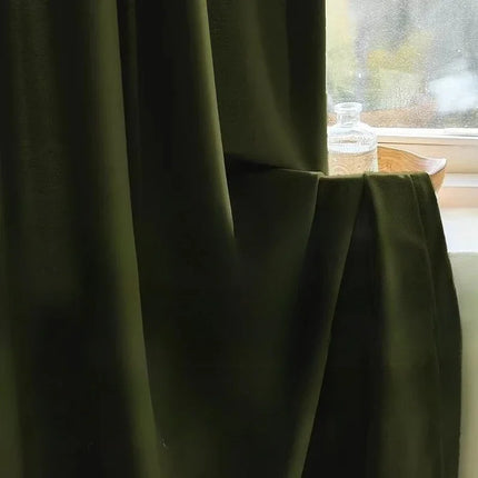 Olive green curtain gathered beside a bright window