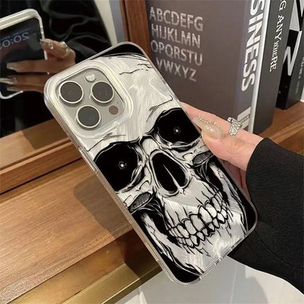 Clear-edged iPhone case with large black and white skull artwork held beside a wooden shelf